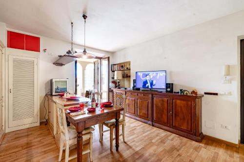 a dining room with a table and a tv at Casa di Allegra Terme di Venturina - Happy Rentals in Campiglia Marittima