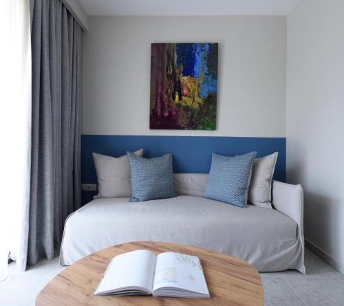a bedroom with a bed and a table with a book at Falena Luxury Rooms in Kalyves Poligirou