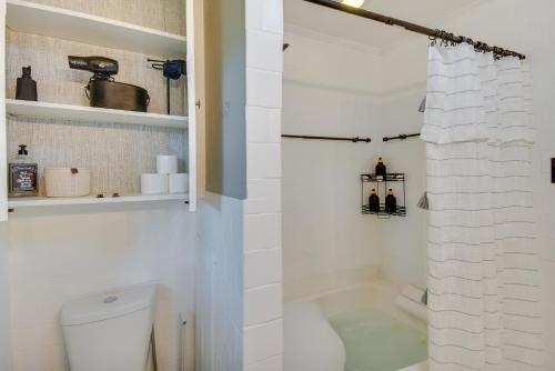 a white bathroom with a shower and a toilet at Charming Hampton Home about 7 Mi to Buckroe Beach! in Hampton