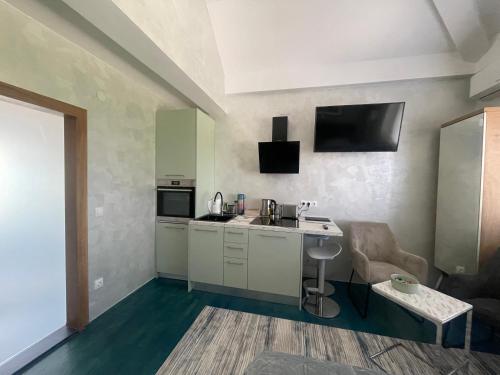 a small kitchen with a sink and a table at Tona - Miran apartman - Parking - Samostalna prijava in Karlovac
