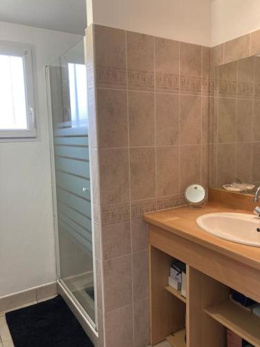 une salle de bain avec une douche en verre et un lavabo dans l'établissement Maison calme avec garage et jardin clos avec ménage inclus, à Le Fenouiller