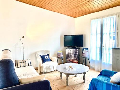 un salon avec un canapé et une télévision dans l'établissement Maison calme avec garage et jardin clos avec ménage inclus, à Le Fenouiller