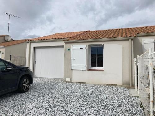 une voiture garée devant une maison avec deux portes de garage dans l'établissement Maison calme avec garage et jardin clos avec ménage inclus, à Le Fenouiller