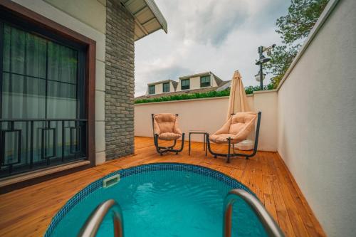 a patio with two chairs and a swimming pool at Alfa Suites & SPA in Sapanca