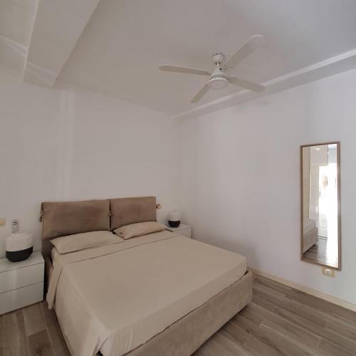 a white bedroom with a bed and a ceiling fan at Sunset Studio - Cabral Beach in Sal Rei