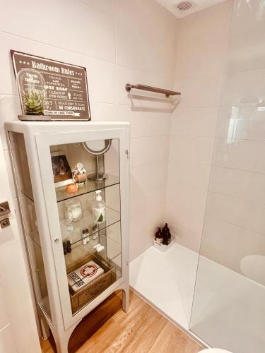 a bathroom with a glass shower stall with a shelf at Loft de estilo industrial con jardín y garaje privados in Valladolid