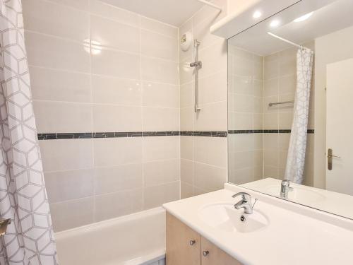 une salle de bain avec un lavabo, une baignoire et un miroir dans l'établissement Appartement lumineux Centre station Terrasse Parking couvert - FR-1-425-197, à Arâches-la-Frasse