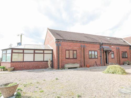 a brick building with a cat in front of it at Stensonhill Lodge in Derby