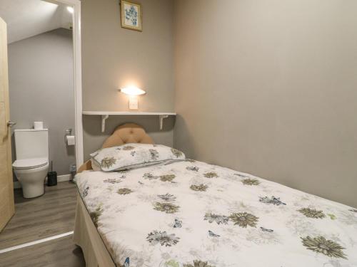 a small bedroom with a bed with a teddy bear on it at Stensonhill Lodge in Derby