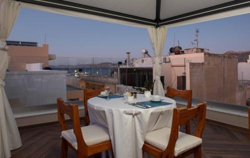 a table and chairs on a balcony with a view at De President Suite, DeMaNi President Suites in Sitia