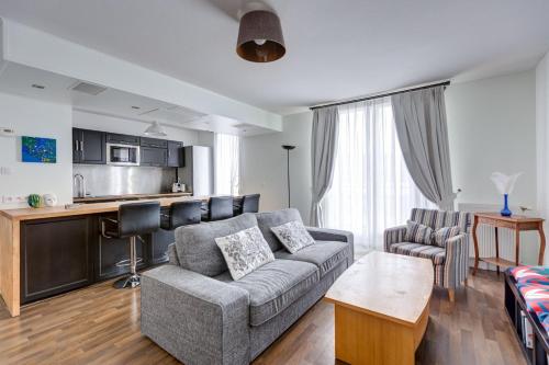 un salon avec un canapé et une cuisine dans l'établissement GuestReady - Appartement de charme à Bordeaux, à Bordeaux