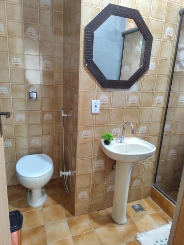 a bathroom with a toilet and a sink and a mirror at Residencial 7 Mares in Rio das Ostras
