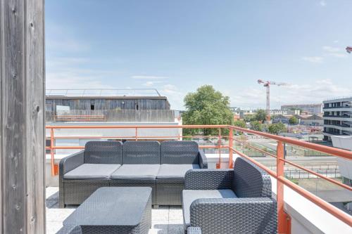 un balcon avec des chaises et des tables sur un immeuble dans l'établissement GuestReady - Appartement de charme à Bordeaux, à Bordeaux