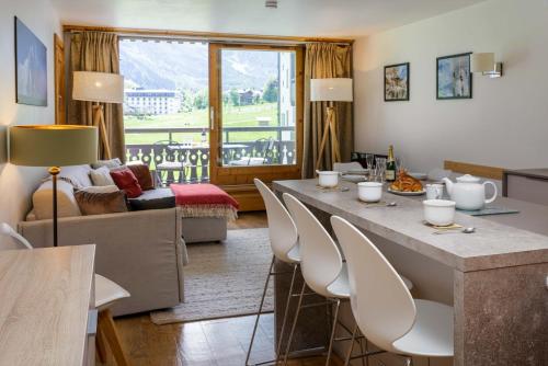 un salon avec une grande table et des chaises dans l'établissement Les Balcons du Savoy 104 appt - Chamonix All Year, à Chamonix-Mont-Blanc