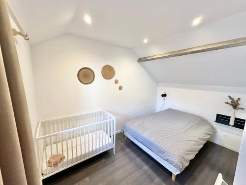 - une chambre avec un lit bébé dans l'établissement Appartements cosy - WIFI - Plage et commerces à 100m, à Berck-sur-Mer