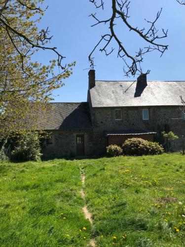 une ancienne maison en pierre avec une cour herbeuse dans l'établissement Charmante maison normande à Brainville à 10mn de la mer, à Brainville