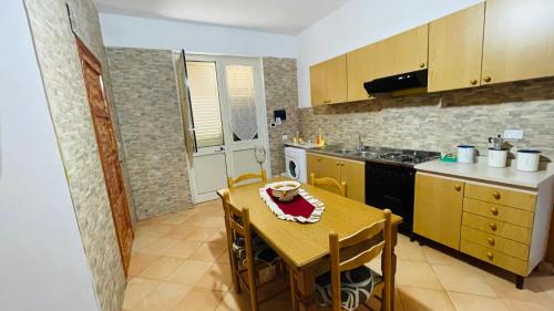 a kitchen with a wooden table and a table and a tableablish at Casa vacanza contrada canalotto 65 in Realmonte