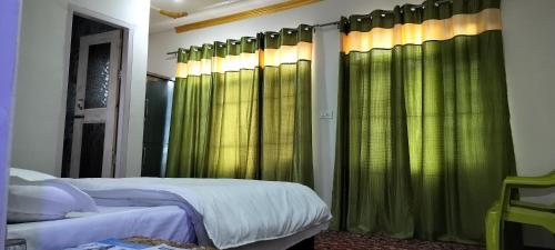 a bedroom with two beds with green curtains at Elizabeth paying guest house Tangmarg gulmarg in Gulmarg