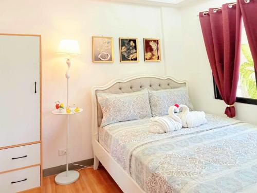 a bedroom with a bed with two swans on it at Secluded Apartment with Full Kitchen & Balcony Garden View in Liloan