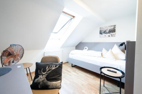 a small bedroom with a bed and a table at Gasthaus Rössle in Nenzing
