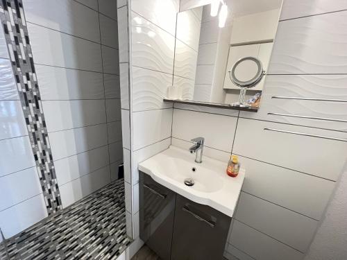 une salle de bain avec un lavabo et un miroir dans l'établissement Sol-y-days, Sables d'or, résidence avec piscine, studio cabine moderne avec balcon, à La Grande Motte