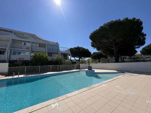 une piscine devant un immeuble dans l'établissement Sol-y-days, Sables d'or, résidence avec piscine, studio cabine moderne avec balcon, à La Grande Motte