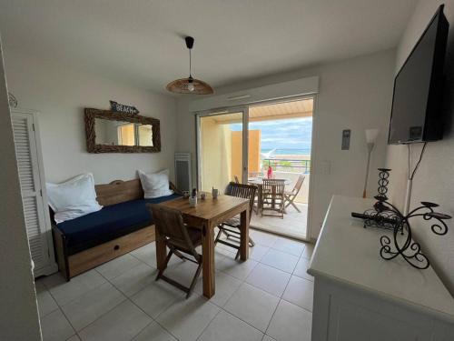un salon avec un lit et une table dans l'établissement Studio face mer Saint Pierre La Mer 2BR203, à Saint Pierre La Mer