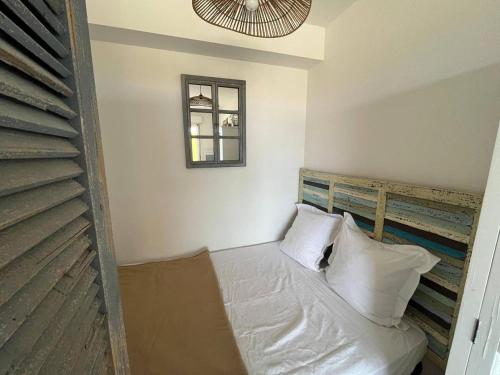 - un lit avec des oreillers blancs dans l'établissement Studio face mer Saint Pierre La Mer 2BR203, à Saint Pierre La Mer