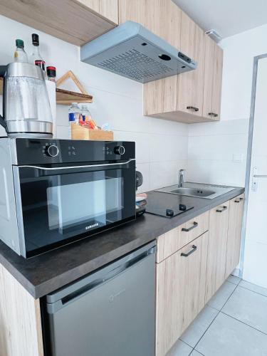 a kitchen with a stove and a microwave at Domus Via Domitia in Narbonne
