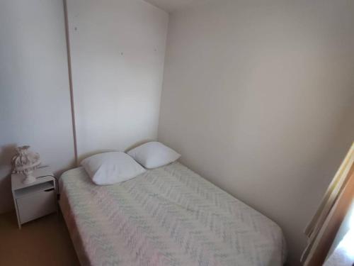 - une petite chambre avec un lit et une petite table dans l'établissement Appartement T2 avec loggia à 100m de la plage - 4SEN119 St Pierre, à Saint Pierre La Mer