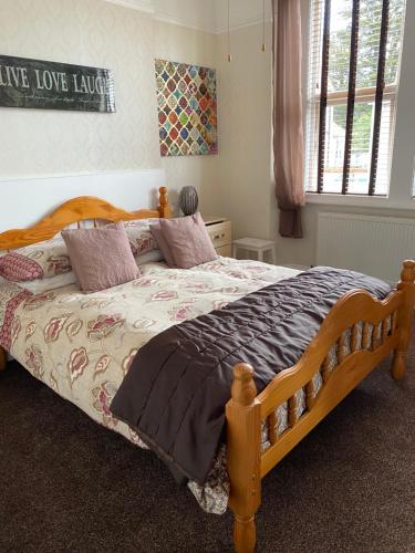 a bedroom with a bed with a wooden frame at Milton Lodge in Weston-super-Mare
