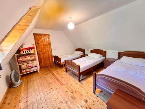 una camera con due letti e una scala di Guest House Gjelaj a Theth