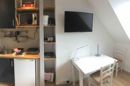 une pièce avec un bureau et une télévision sur un mur dans l'établissement Studio COZY, à Chambéry