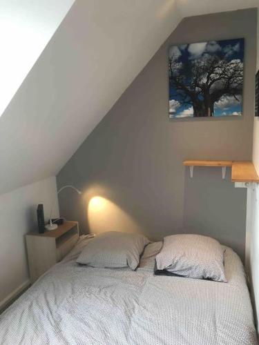 - un lit avec deux oreillers dans une chambre avec un arbre dans l'établissement Studio COZY, à Chambéry