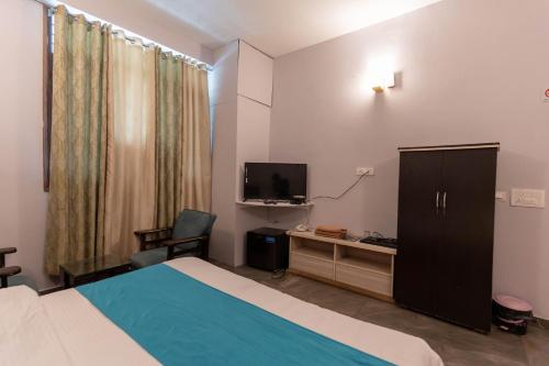 KhararにあるShivjot hotelのベッドとテレビが備わるホテルルームです。