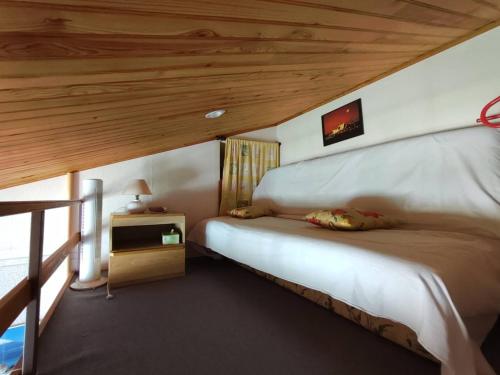 une chambre avec un lit avec un plafond en bois dans l'établissement Appartement pour 4 personnes - 4LBM498, à Narbonne-Plage