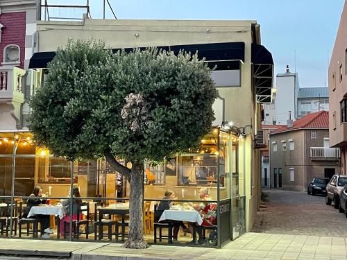 un albero davanti a un ristorante con persone sedute ai tavoli di Aqui Há Gato a Vila Praia de Âncora