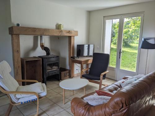 a living room with a couch and a wood stove at Maison au calme en Dordogne in Trémolat