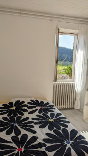 - une chambre avec un lit noir et blanc et une fenêtre dans l'établissement Maison au calme en Dordogne, à Trémolat