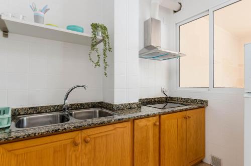 a kitchen with a sink and a window at Port Apartments in Port d'Alcudia