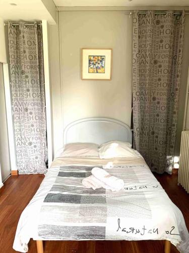 - un petit lit dans une chambre avec des rideaux dans l'établissement Studio GLYCINE, à Chambéry