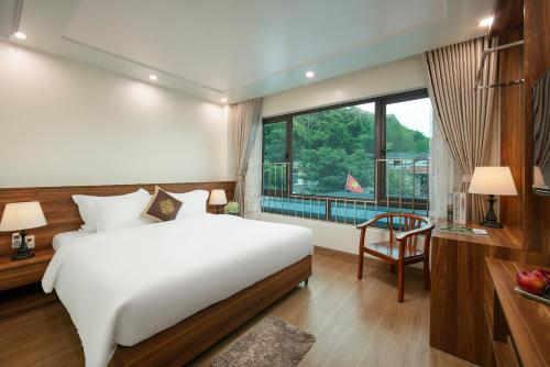 DUNG LAI HOTEL 173 في كات با: غرفة نوم بسرير ومكتب ونافذة