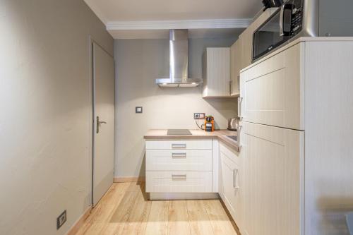  La cuisine est équipée de placards blancs et d'un réfrigérateur. dans l'établissement T2 coeur de vieille ville, à Annecy