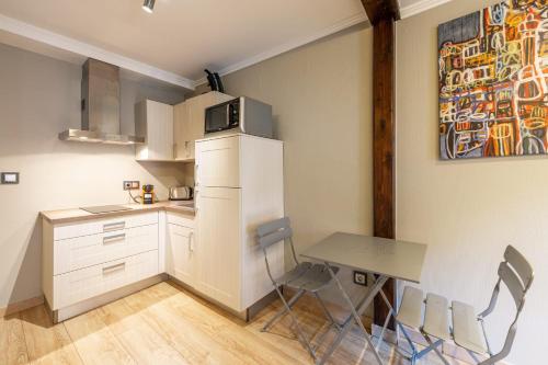 une petite cuisine avec une table et un réfrigérateur dans l'établissement T2 coeur de vieille ville, à Annecy
