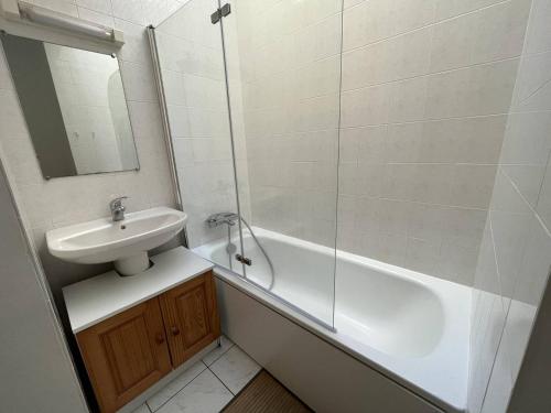 une salle de bain avec un lavabo, une baignoire et un miroir dans l'établissement Appartement Calme avec Terrasse, Piscine et Parking à 250m de la Plage - FR-1-324A-16, à Saint-Hilaire-de-Riez