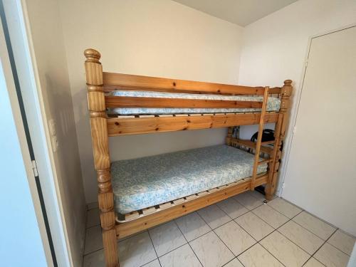 - un lit superposé en bois dans l'angle d'une chambre dans l'établissement Appartement Calme avec Terrasse, Piscine et Parking à 250m de la Plage - FR-1-324A-16, à Saint-Hilaire-de-Riez