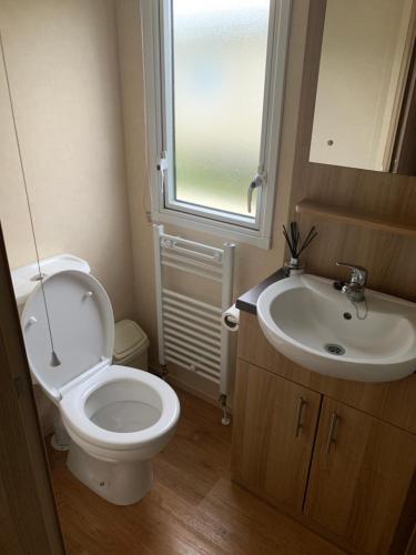 a bathroom with a toilet and a sink at Keeonah 220 Kestrel Close in Saltfleet