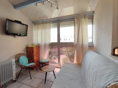 une chambre avec un lit, une télévision et une fenêtre dans l'établissement Appartement à 25m de la plage - 4LBM359 Narbonne Plage, à Narbonne-Plage