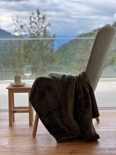 a chair with a blanket sitting next to a table at Chalet Tschattlhof Dolomites in Ponte Nova