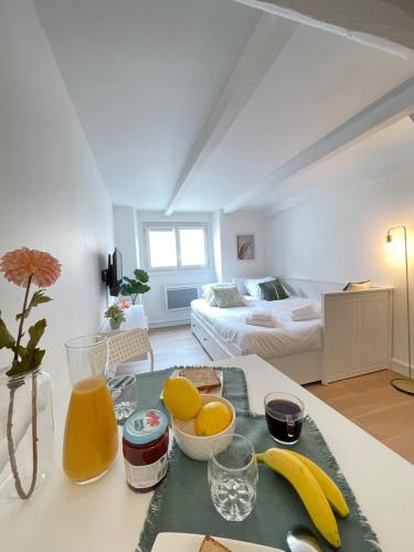 un salon avec une table avec de la nourriture et des fruits dessus dans l'établissement A NE PAS MANQUER Studio plein centre d Avignon climatisé, à Avignon